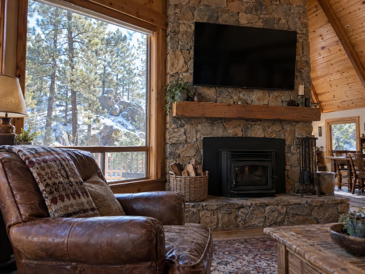 A TV mounted level on a stacked-stone cabin fireplace with no cables showing